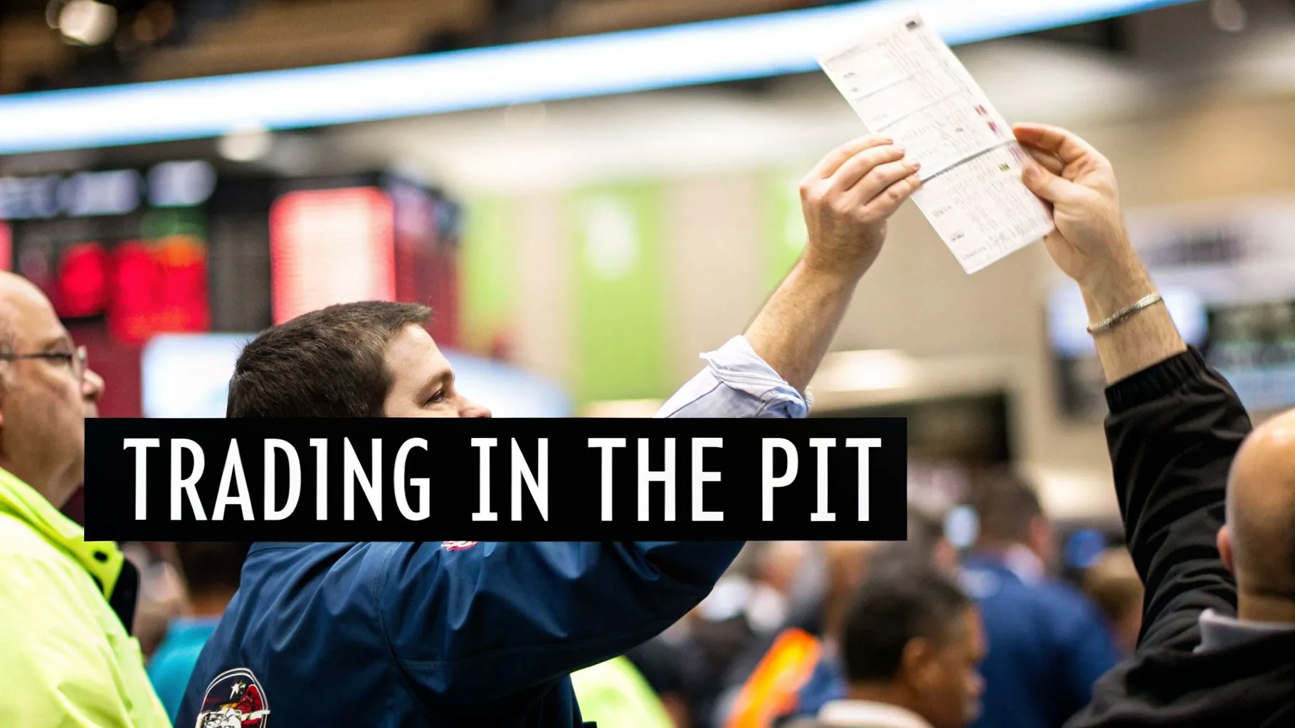 Traders actively participate in a busy financial pit, raising hands with trading tickets.