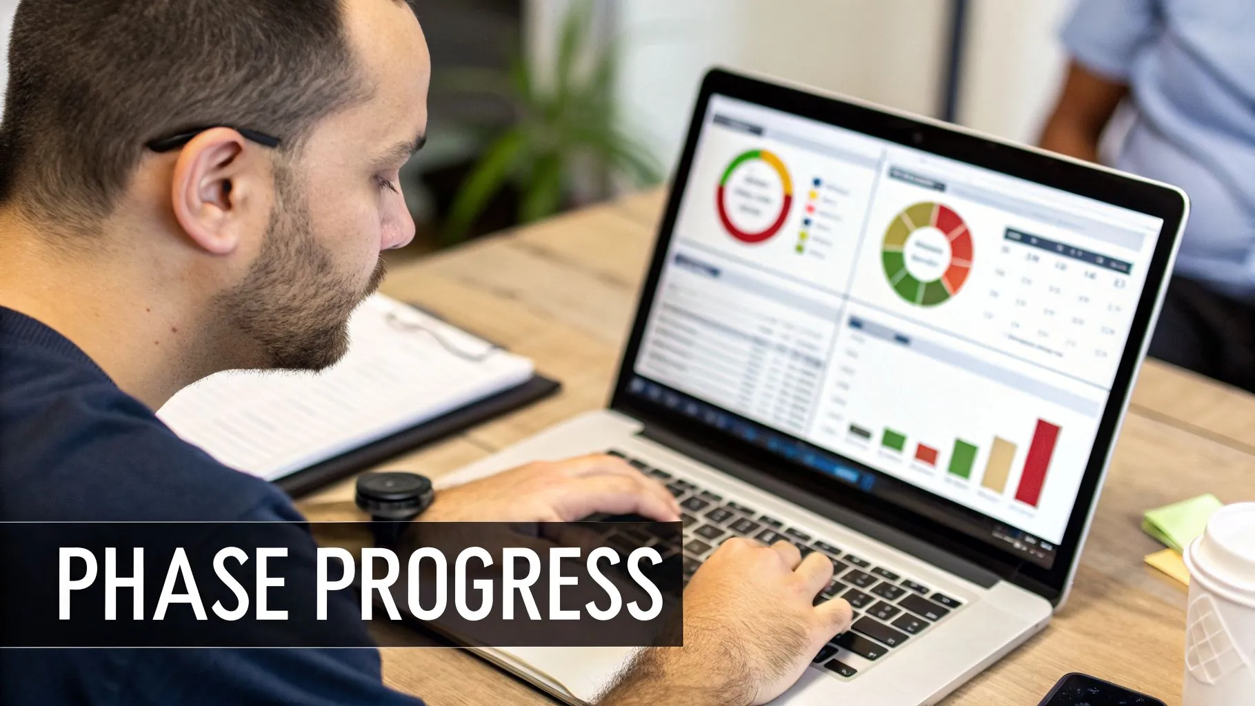 A man focused on a laptop screen displaying various charts and graphs representing phase progress.